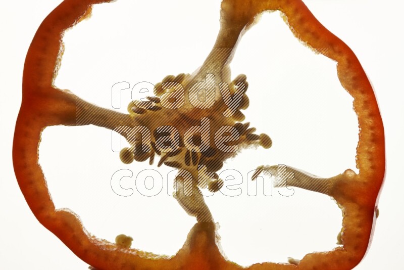 Red bell pepper slices on illuminated white background