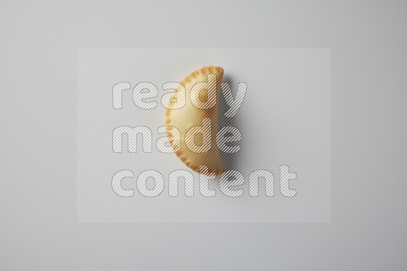One fried sambosa from a top angle on a white background