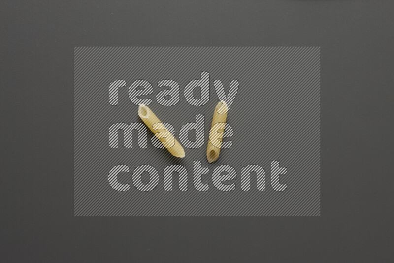 Mini penne pasta on grey background
