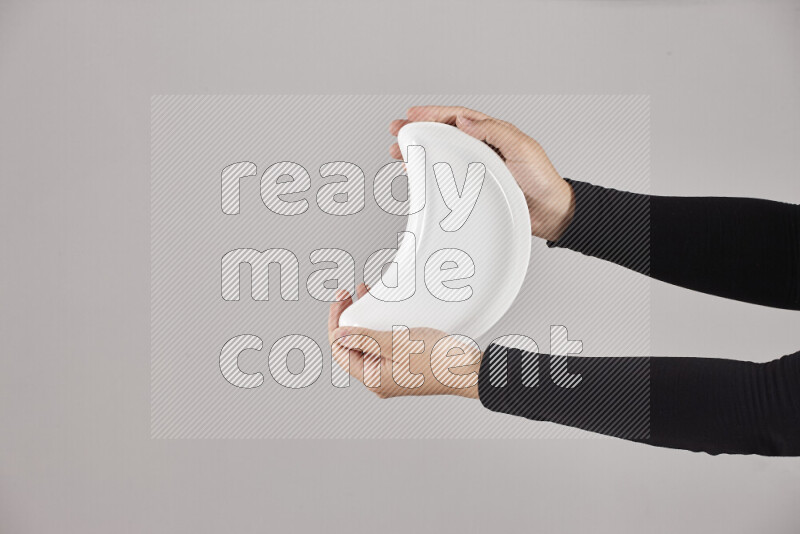 A woman in black abaya holding different pottery essentials in different positions