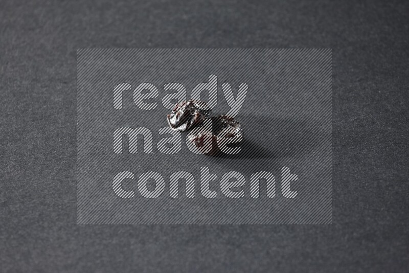 Two dried plums on a black background in different angles