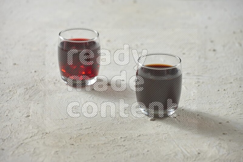 Cold drinks in a glass cup such as water, tamarind, qamar eldin, sobia, milk and hibiscus on textured white background
