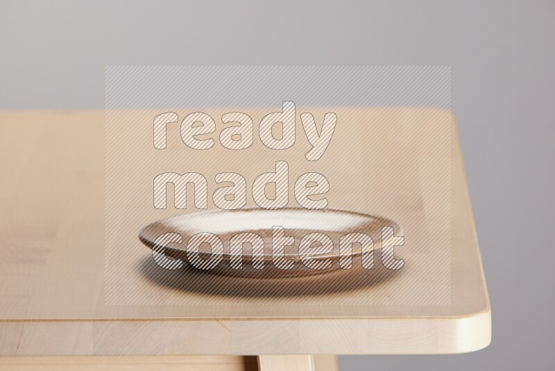 multi-colored pottery Plate on a wooden table edge