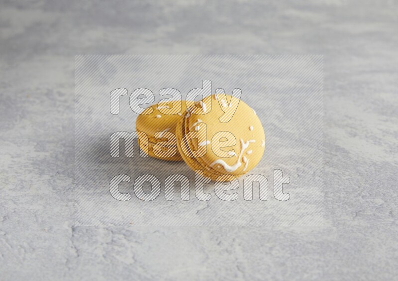 45º Shot of two Yellow Piña Colada macarons  on white  marble background