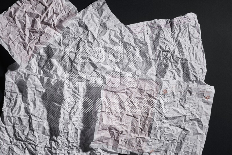 Crumpled notebook sheet on black background