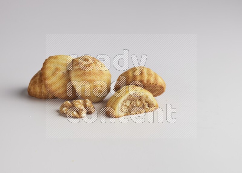 Five Pieces of Maamoul filled with walnut paste  one of them is cut with direct on white background