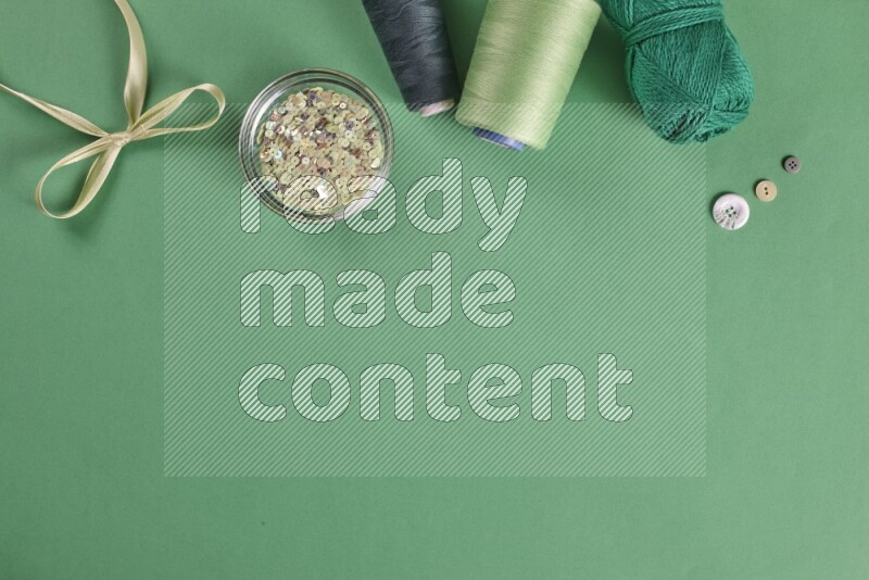 مجموعة من أدوات الخياطة والتفصيل خضراء اللون على خلفية خضراء