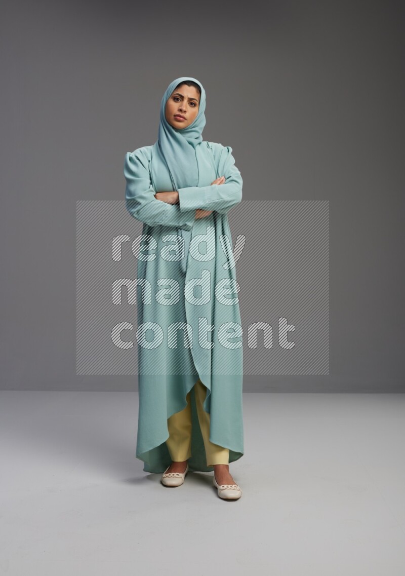 Saudi Woman wearing Abaya standing with crossed arms on Gray background