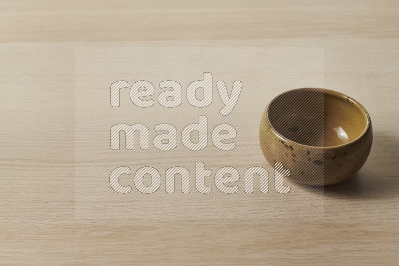 A multicolored pottery bowl on light wooden background
