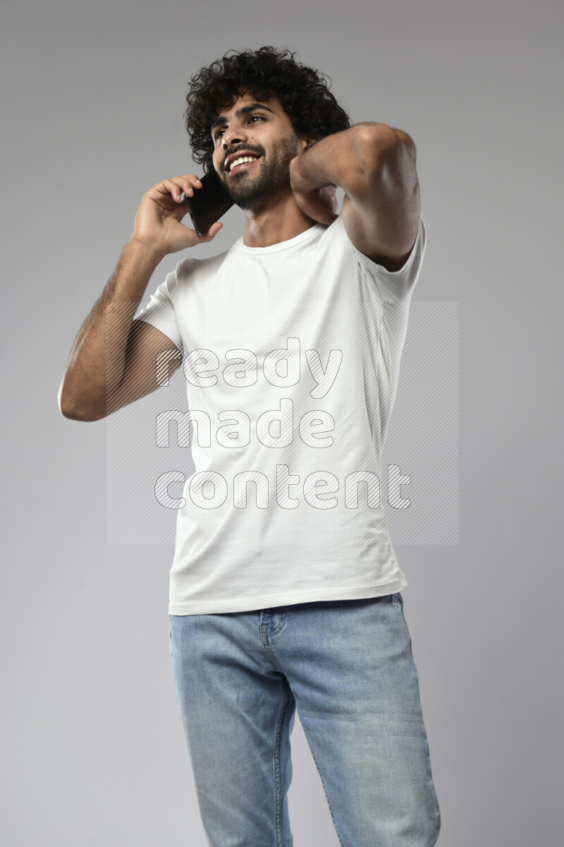 A man wearing casual standing and talking on the phone on white background