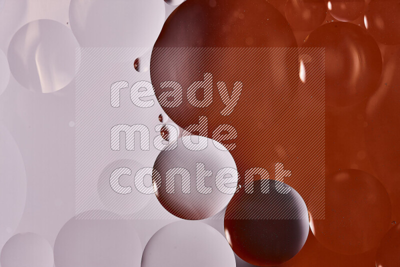 Close-ups of abstract oil bubbles on water surface in shades of white and orange
