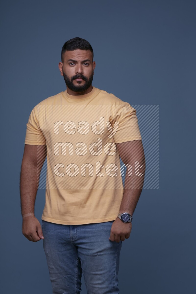 رجل يرتدي قميص اصفر بأكمام قصيرة وبنطال جينز ازرق يقف بأوضاع مختلفة