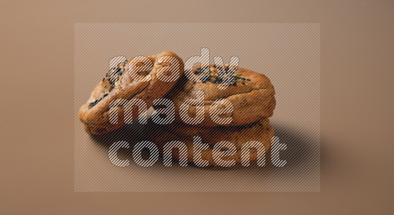 Hasawi cookies field with date and decorated by black seed and Anise grain on a brown background