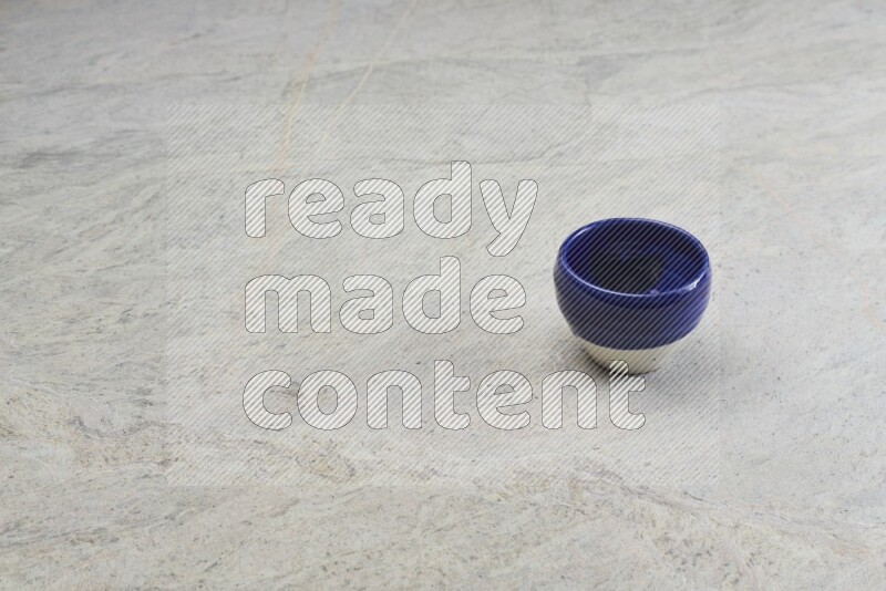 A multicolored pottery bowl on grey marble background