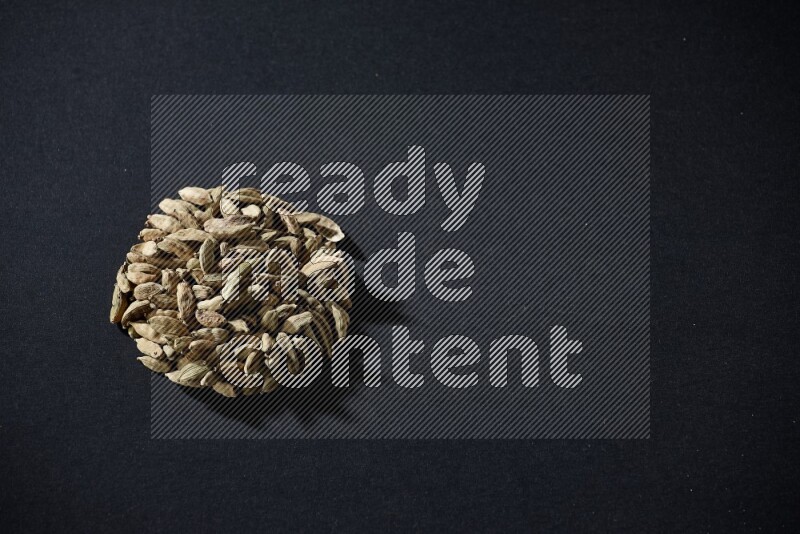 Cardamom in a circle shape on black flooring