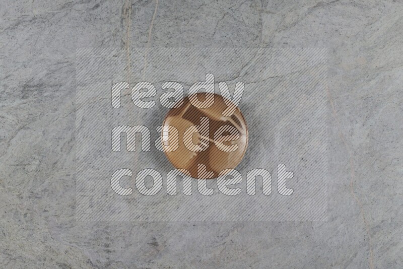 A multicolored pottery plate on grey marble background