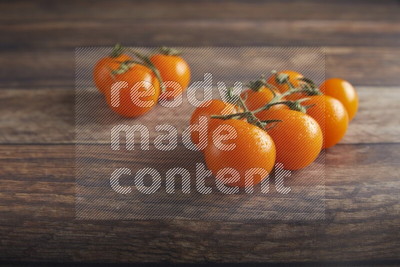 Orange cherry tomato vein on a textured wooden background 45 degree
