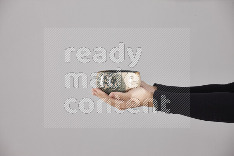 A woman in black abaya holding different pottery essentials in different positions