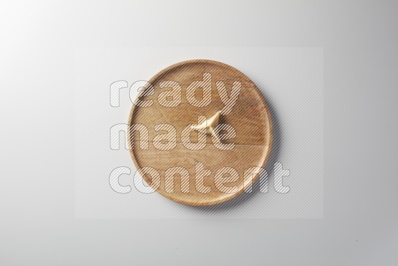 A single Sambosa on a wooden round plate on a white background