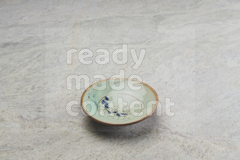 A decorative pottery plate on grey marble background