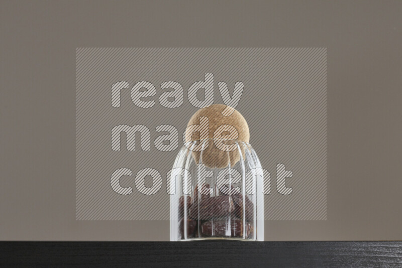 Dates in a glass jar on black background