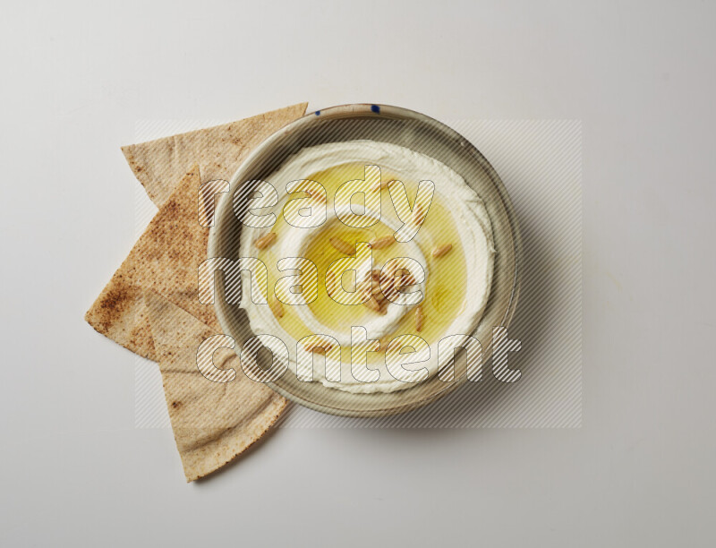 Lebnah garnished with pine nuts in a grey pottery plate on a white background