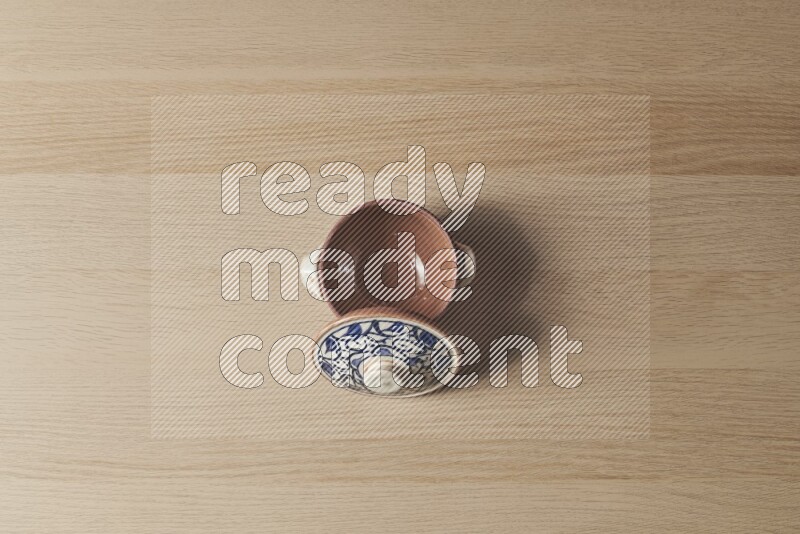 A multicolored pottery pot on light wooden background
