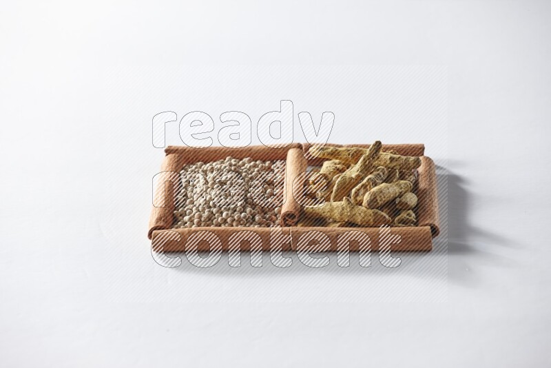 2 squares of cinnamon sticks full of white pepper and turmeric fingers on white flooring