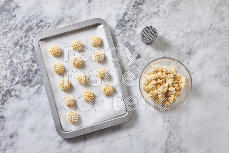 Kahk step by step with its ingredients ghee, sugar, flour, sesame, yeast, water and kahk flavor on grey marble background
