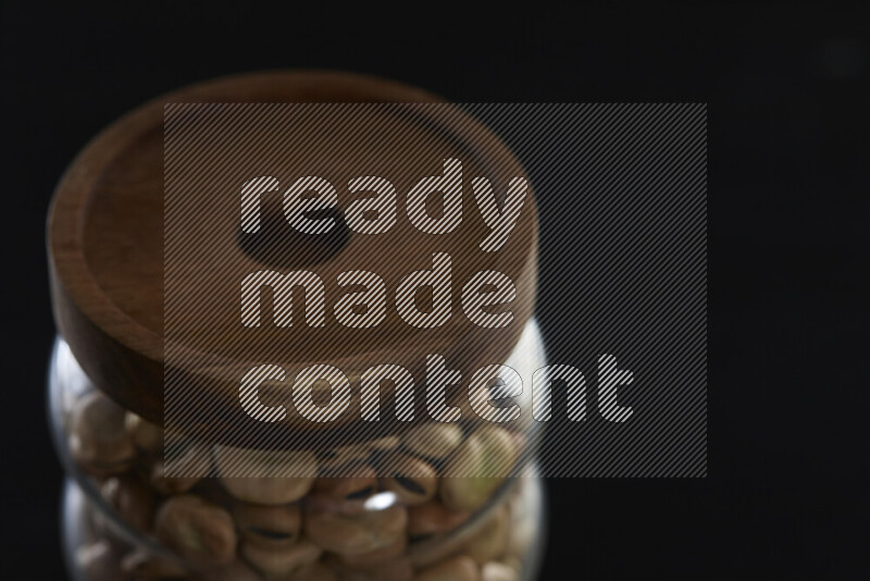 فول تدميس في وعاء زجاجي على خلفية سوداء