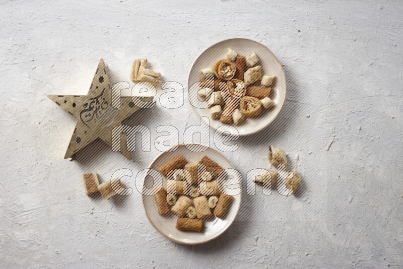 Oriental sweets in pottery plates with a lantern in a light setup