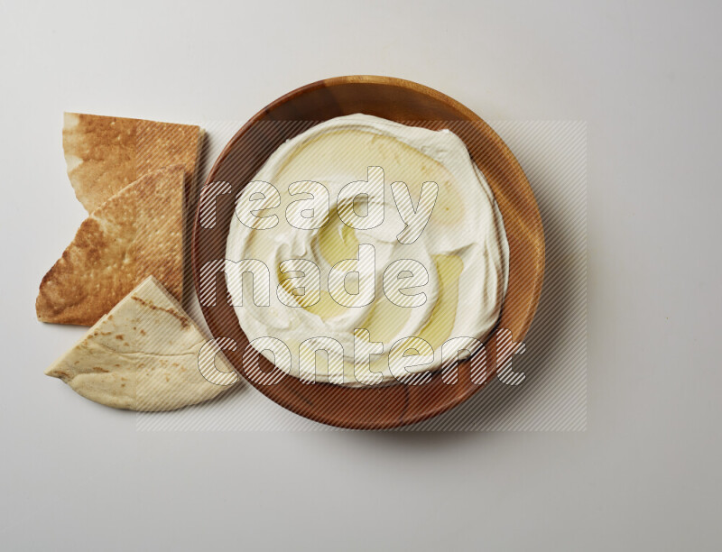 Lebnah garnished with olive oil in a wooden plate on a white background