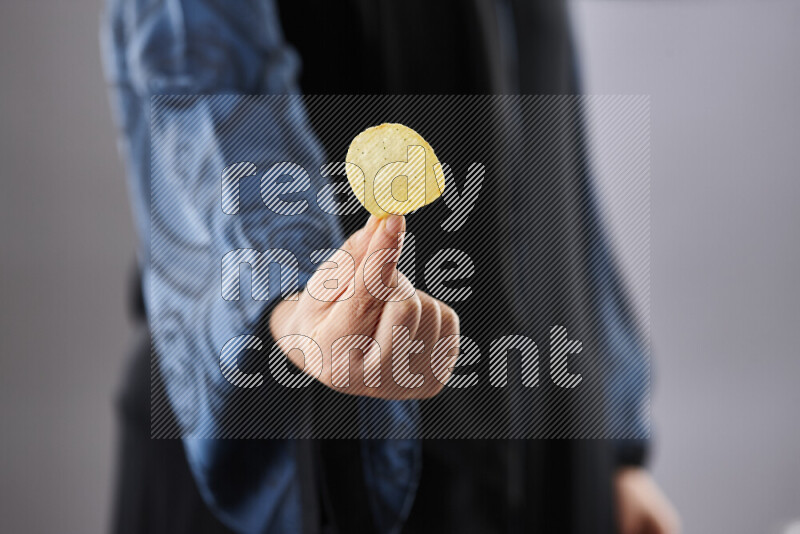 Woman in abaya holding different kinds of snacks in different positions