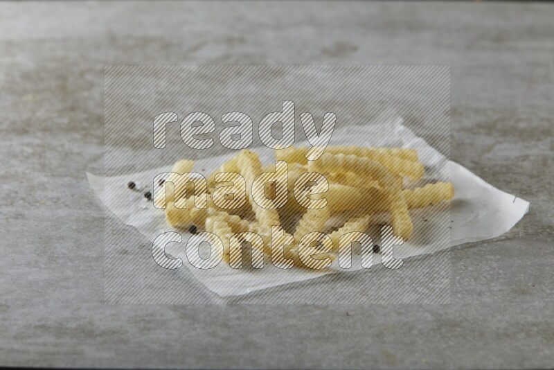 crinkle fries on parchment paper on grey textured counter top