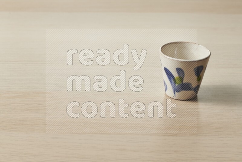 A pottery cup on light wooden background