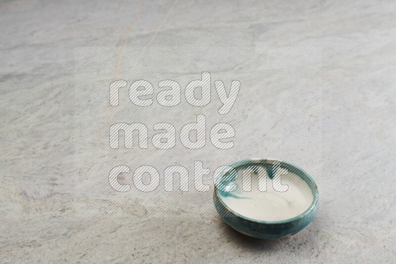 A multicolored pottery bowl on grey marble background