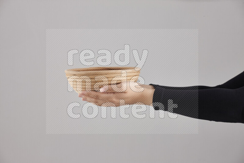 A woman in black abaya holding different wooden essentials in different positions