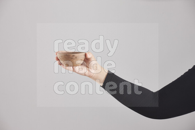A woman in black abaya holding different wooden essentials in different positions