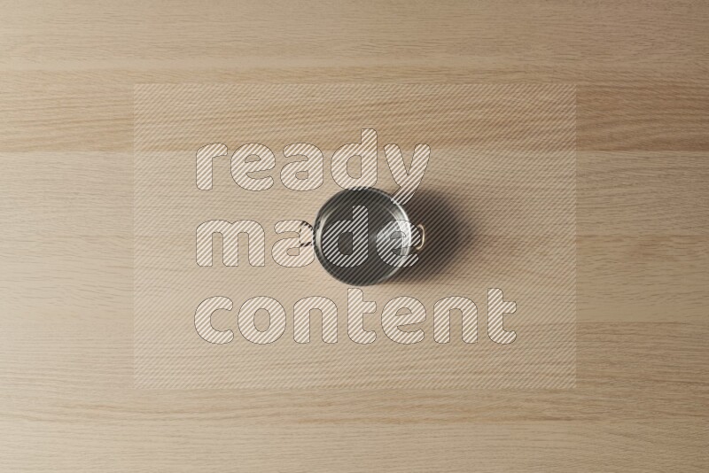 A small copper pot on light wooden background