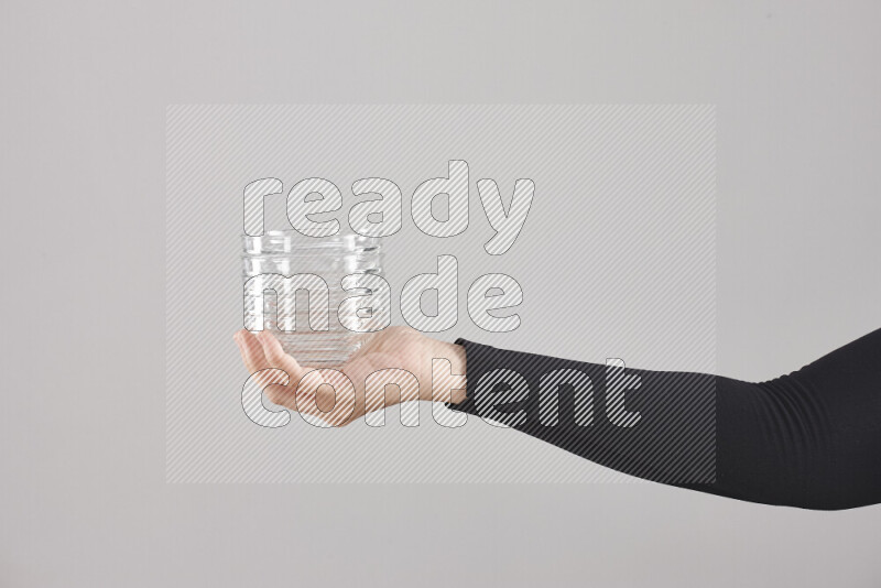 امرأة ترتدي عباءة سوداء تحمل أدوات زجاجية مختلفة في أوضاع متعددة