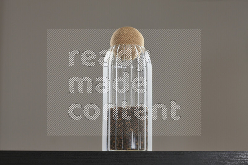 Dried basil in a glass jar on black background