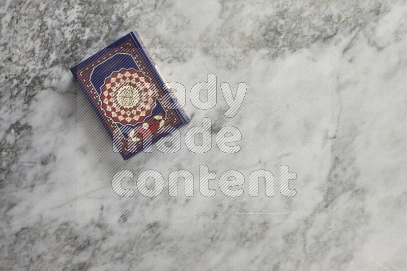 Quran with a prayer beads on grey marble background