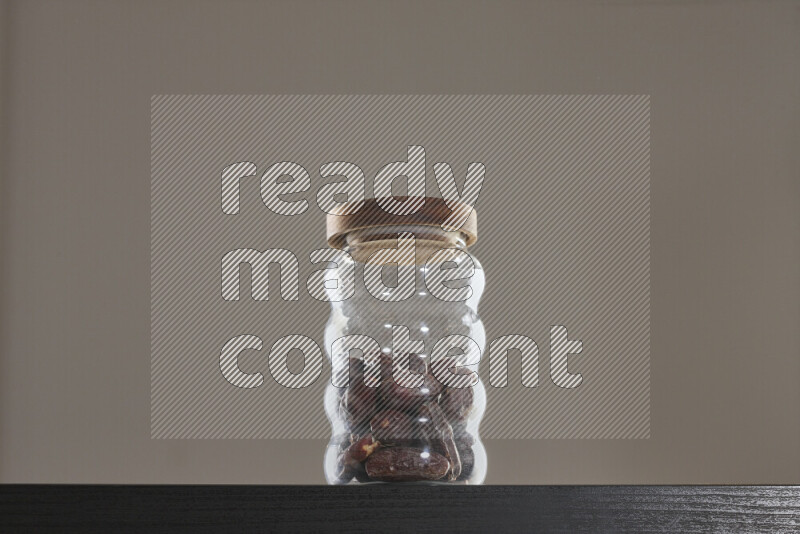 Dates in a glass jar on black background
