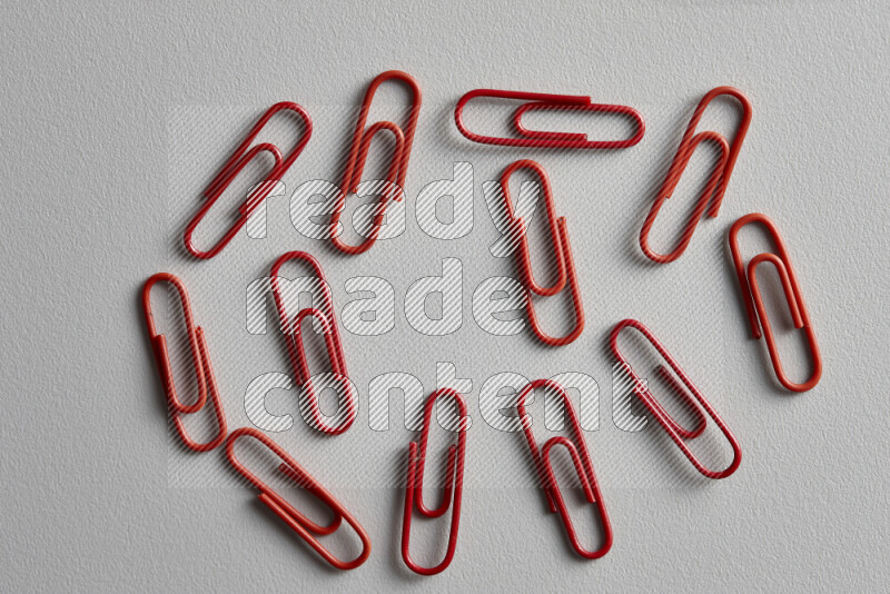 Red paper clips isolated on a grey background