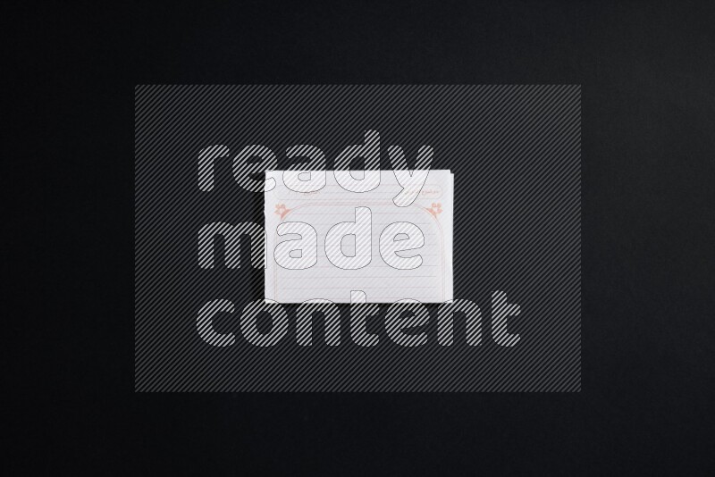 Folded notebook sheet on black background