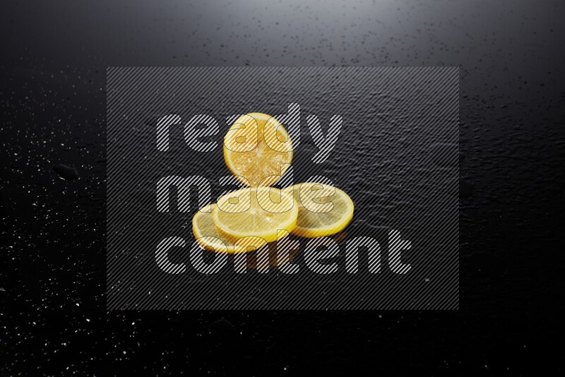 Lemon slices with water drops, and droplets on black background