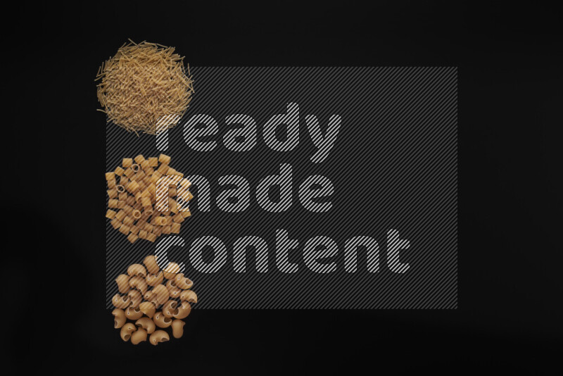 Different pasta types in 3 bunches on black background