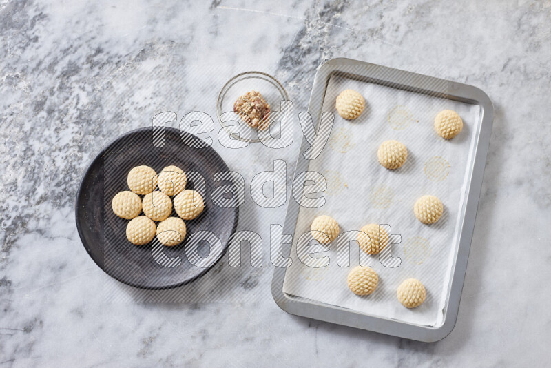 Kahk step by step with its ingredients ghee, sugar, flour, sesame, yeast, water and kahk flavor on grey marble background