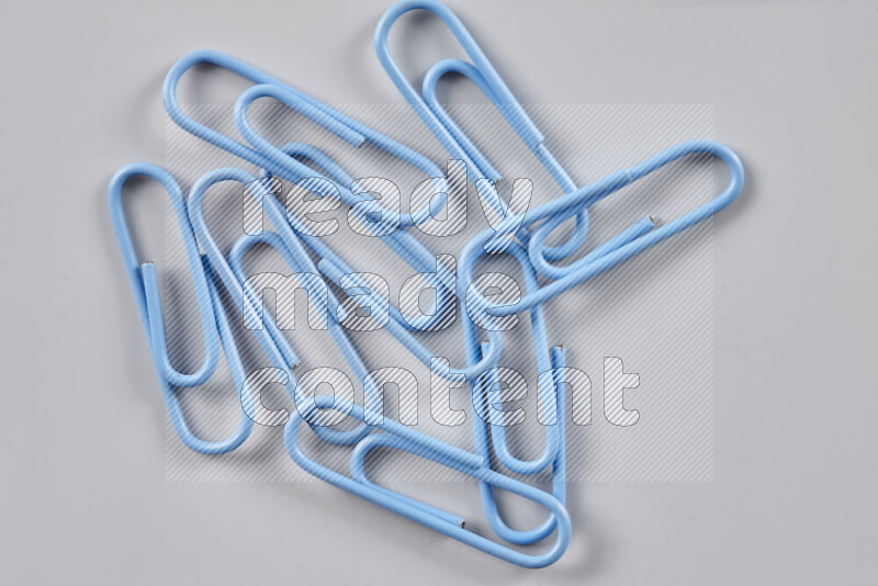 Blue paper clips isolated on a grey background