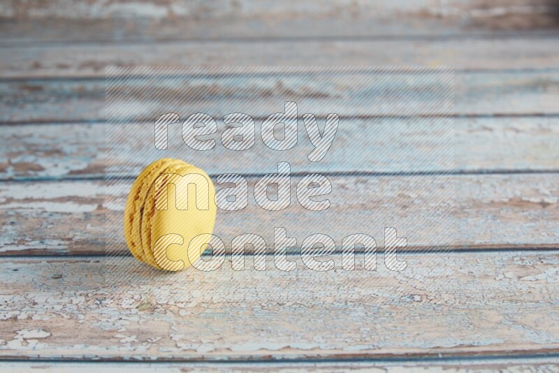 45º Shot of Yellow Lemon macaron on light blue wooden background